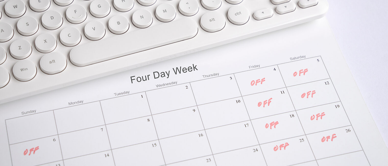 Calendar with four day work week, off days on Friday, Saturday and Sunday. Office desk with keyboard.