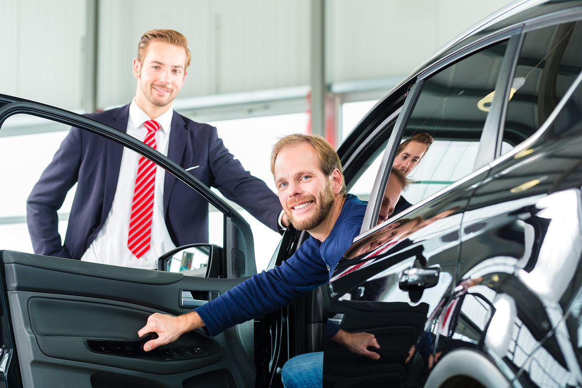 Seller or car salesman and client or customer in car dealership presenting the interior decoration of new and used cars in the showroom Schlagwort(e): auto, car, dealer, Man, client, dealership, salesman, seller, sale, buy, buying, customer, retail, purchase, purchasing, presentation, suit, white, business, new, used, profession, work, working, occupation, consult, service, male, female, businesslike, showroom, sales, standing, male, young, showing, people, Caucasian, mann, kunde, auto, autohaus, verkäufer, autokauf, autohandel, handel, händler, autohändler, neuwagen, interessentin, gebrauchtwagen, kaufen, verkaufen, anzug, präsentation, zeigen, ausstattung, business, kfz, kfz-verkäufer, einzelhandel, geschäft, ausstellungsraum, wagen, beruf, arbeit, arbeiten, beratung, berater, beraten, service, jung, leute