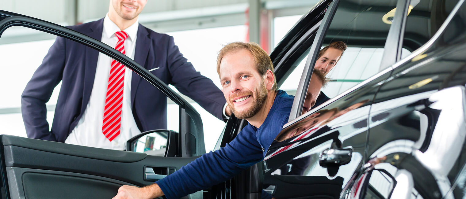 Seller or car salesman and client or customer in car dealership presenting the interior decoration of new and used cars in the showroom Schlagwort(e): auto, car, dealer, Man, client, dealership, salesman, seller, sale, buy, buying, customer, retail, purchase, purchasing, presentation, suit, white, business, new, used, profession, work, working, occupation, consult, service, male, female, businesslike, showroom, sales, standing, male, young, showing, people, Caucasian, mann, kunde, auto, autohaus, verkäufer, autokauf, autohandel, handel, händler, autohändler, neuwagen, interessentin, gebrauchtwagen, kaufen, verkaufen, anzug, präsentation, zeigen, ausstattung, business, kfz, kfz-verkäufer, einzelhandel, geschäft, ausstellungsraum, wagen, beruf, arbeit, arbeiten, beratung, berater, beraten, service, jung, leute