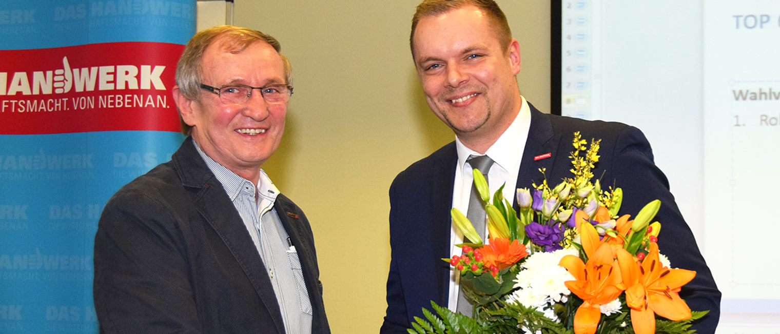 Vollversammlungsmitglied Roland Scheffler (links) gratuliert dem alten und neuen HWK-Präsidenten Robert Wüst.