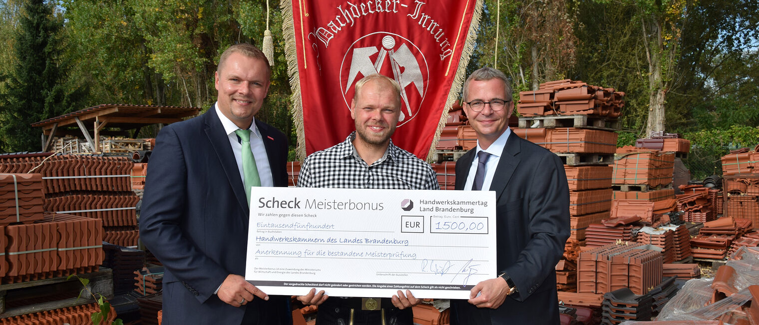 v. l.n.r. Kammerpräsident Robert Wüst, Dachdeckermeister Daniel Kusmiercyk, Wirtschaftsminister Albrecht Gerber