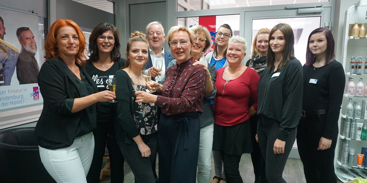Fachkräfte und Lehrlinge aus dem Team der Neuen Linie Friseur und Kosmetik GmbH mit Geschäftsführerin Brita Meißner (5.v.l.) und dem ehemaligen Geschäftsführer Eberhard Nitze (4.v.l.).