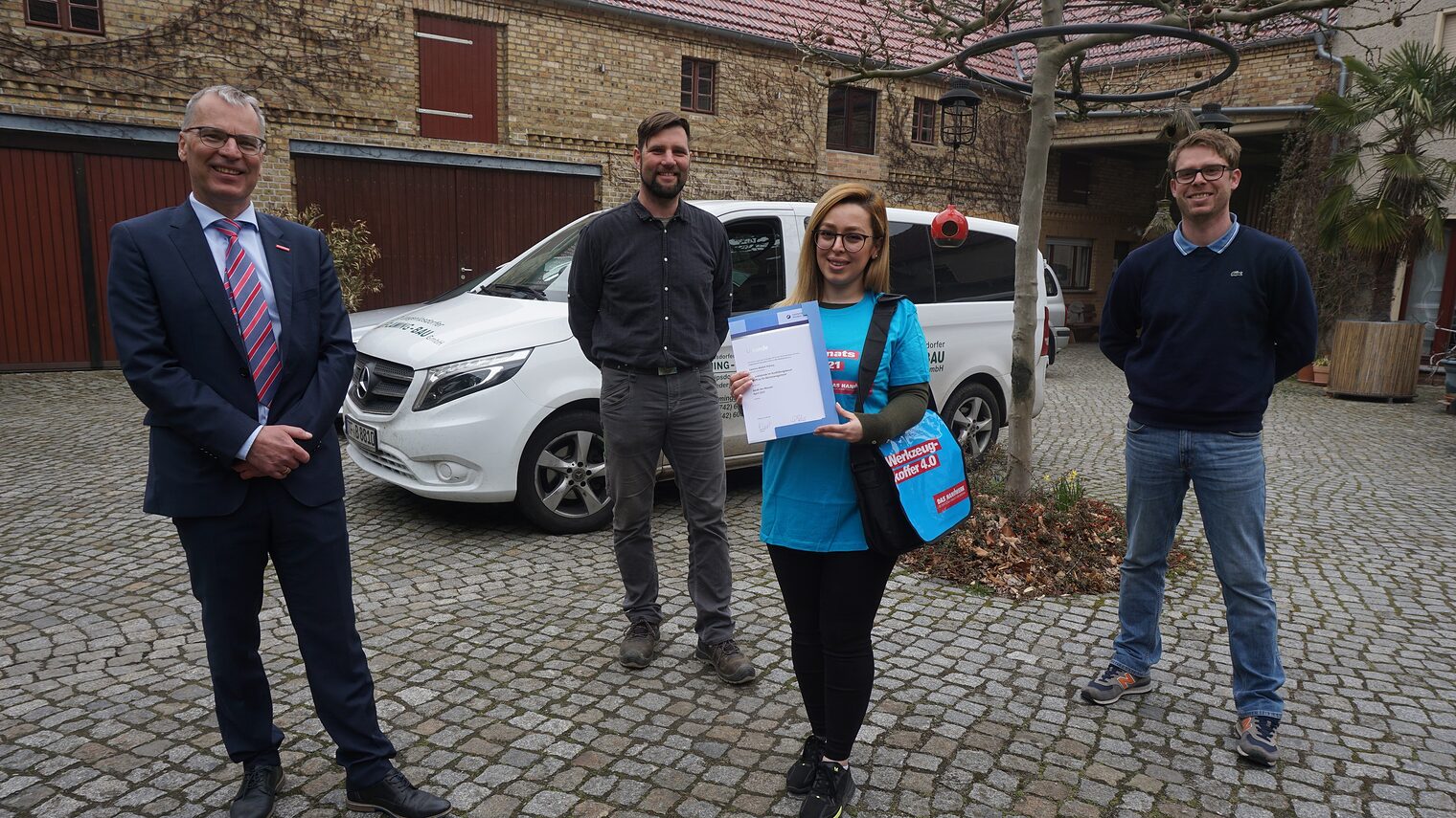 Die angehende Bürokauffrau Samira Abdoli Kolory ist Azubi des Monats April der Handwerkskammer Potsdam. Auf dem Bild mit Tilo Jänsch, Geschäftsführer der Handwerkskammer Potsdam, Maik Liesigk und Matthias Handke von der Langenlipsdorfer Fläming Bau GmbH (v.l.n.r.)