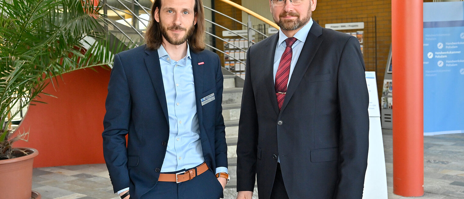 Zwei M&auml;nner im Anzug in einer Lobby 