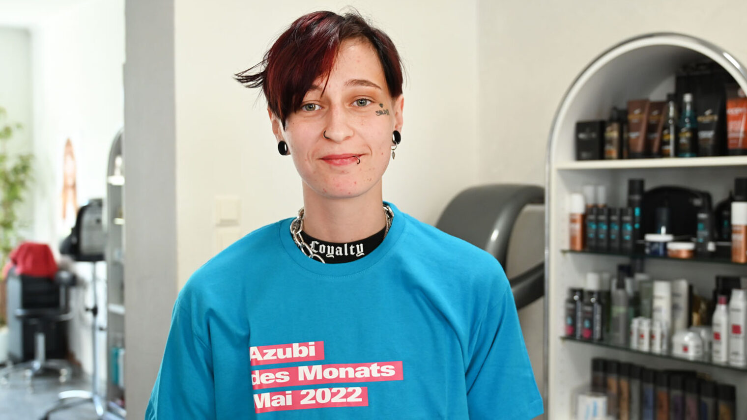 junge Frau im blauen T-Shirt mit der Aufschrift "Azubi des Monats Mai 2022. Das Handwerk" 