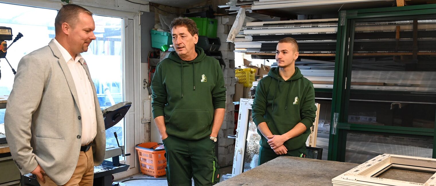 Glasermeister Karsten Fugmann und sein Sohn Niclas mit HWK-Präsident Robert Wüst in der Werkstatt. 