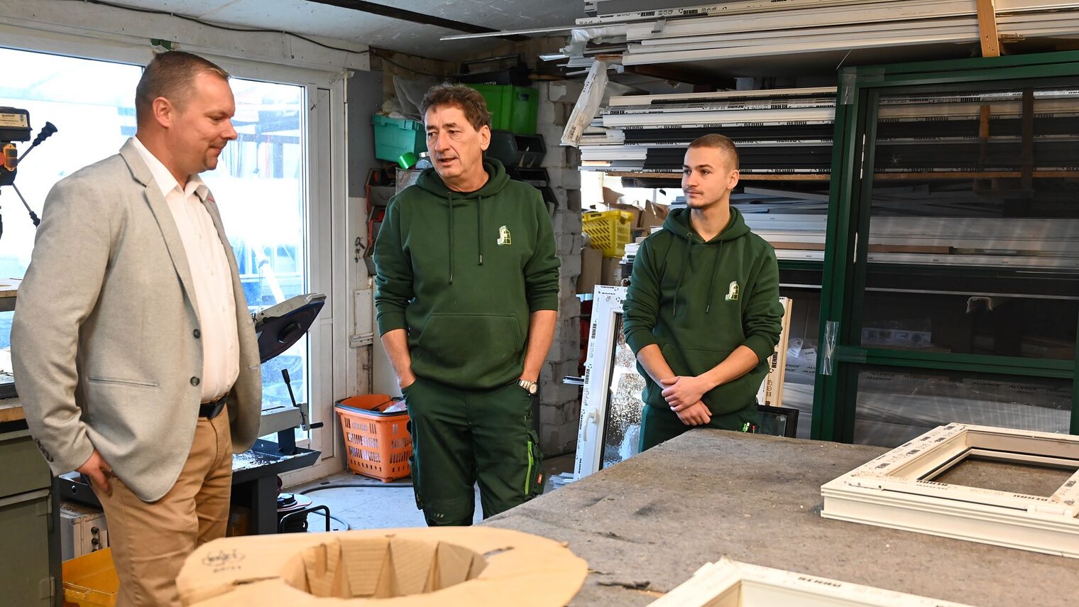 Glasermeister Karsten Fugmann und sein Sohn Niclas mit HWK-Präsident Robert Wüst in der Werkstatt. 