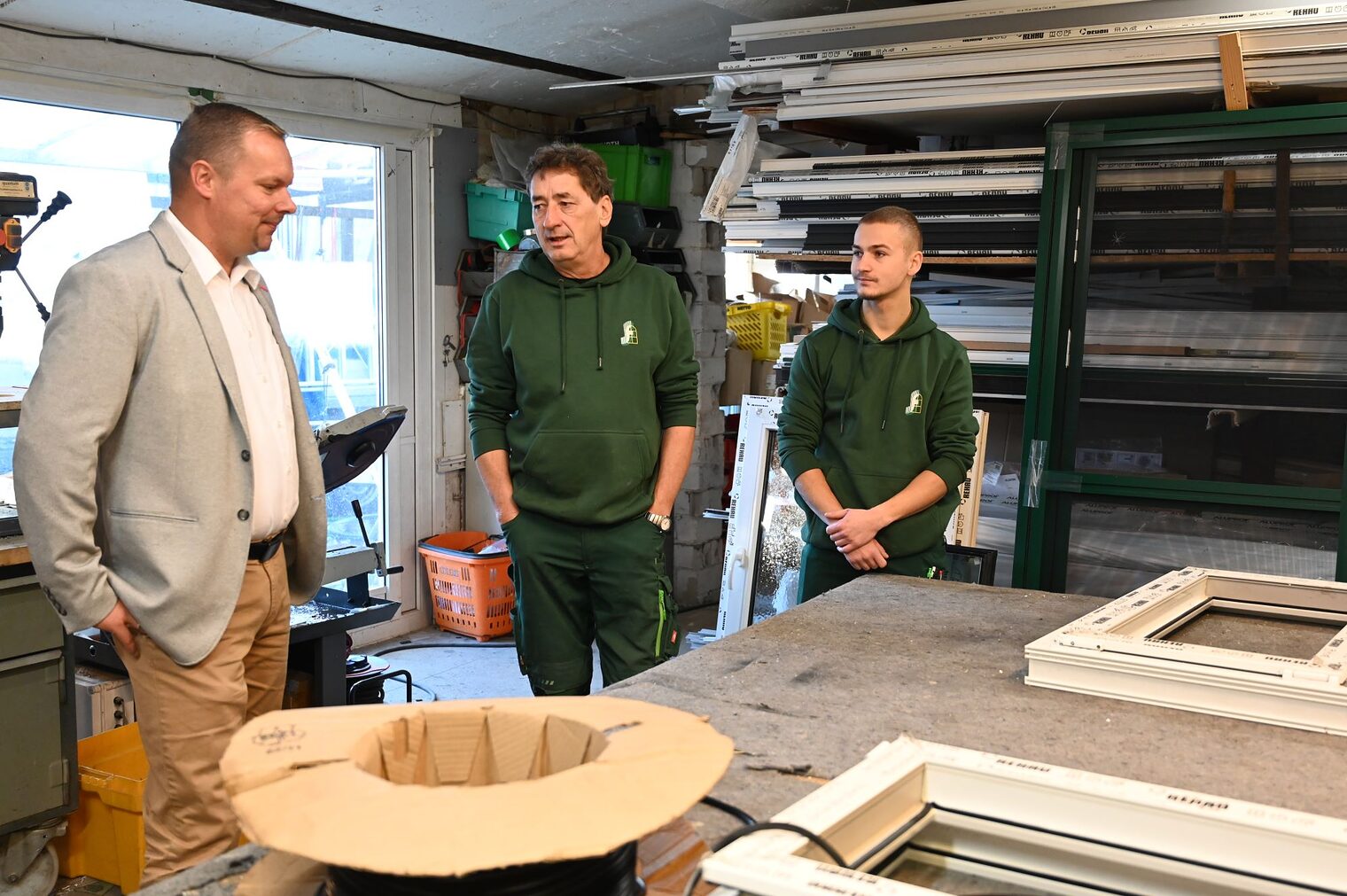 Glasermeister Karsten Fugmann und sein Sohn Niclas mit HWK-Präsident Robert Wüst in der Werkstatt. 
