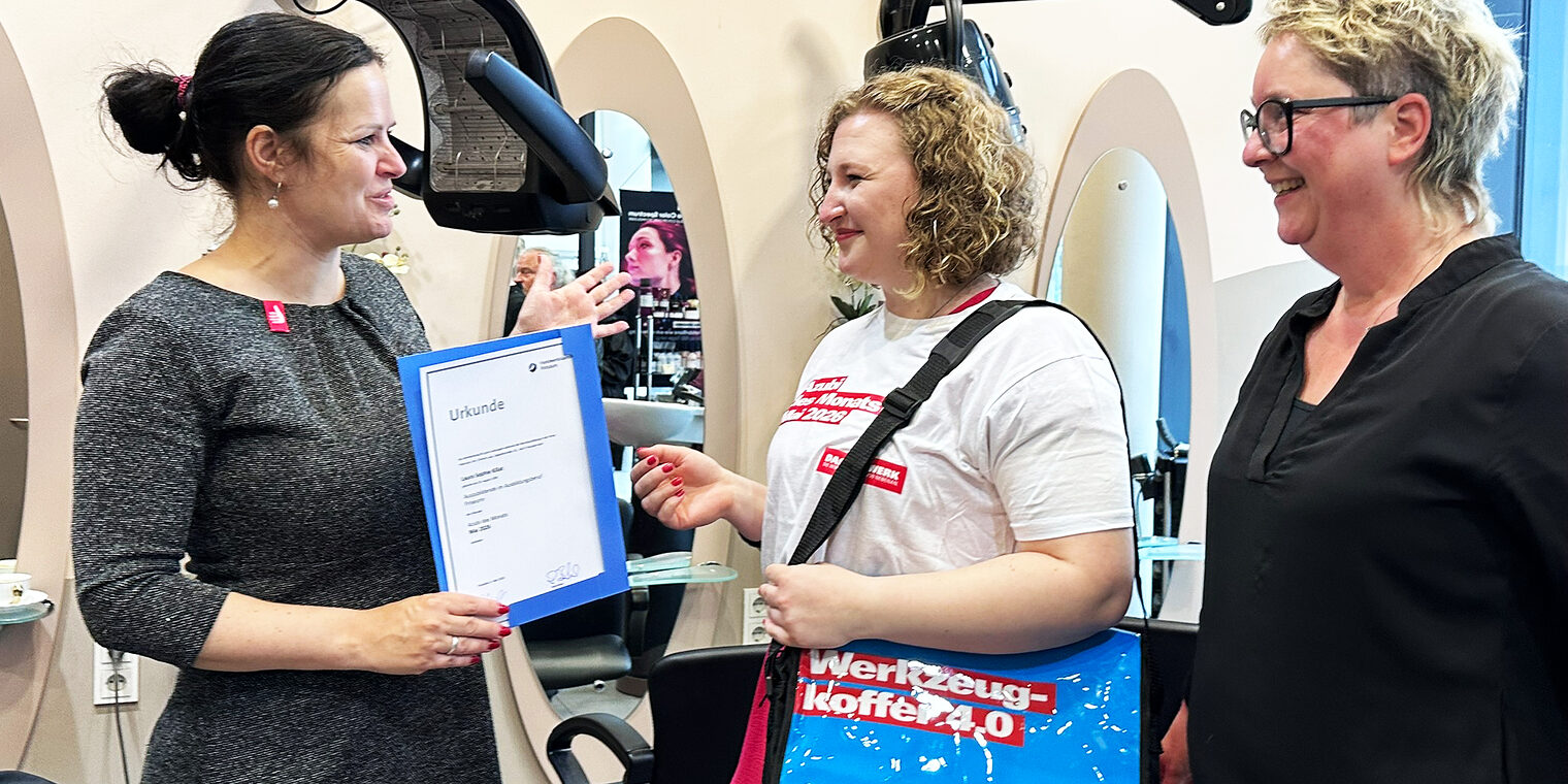Steffi Amelung, Abteilungsleiterin Berufsbildung bei der Handwerkskammer Potsdam, gratuliert Laura Killat und Friseurmeisterin Christin Lack